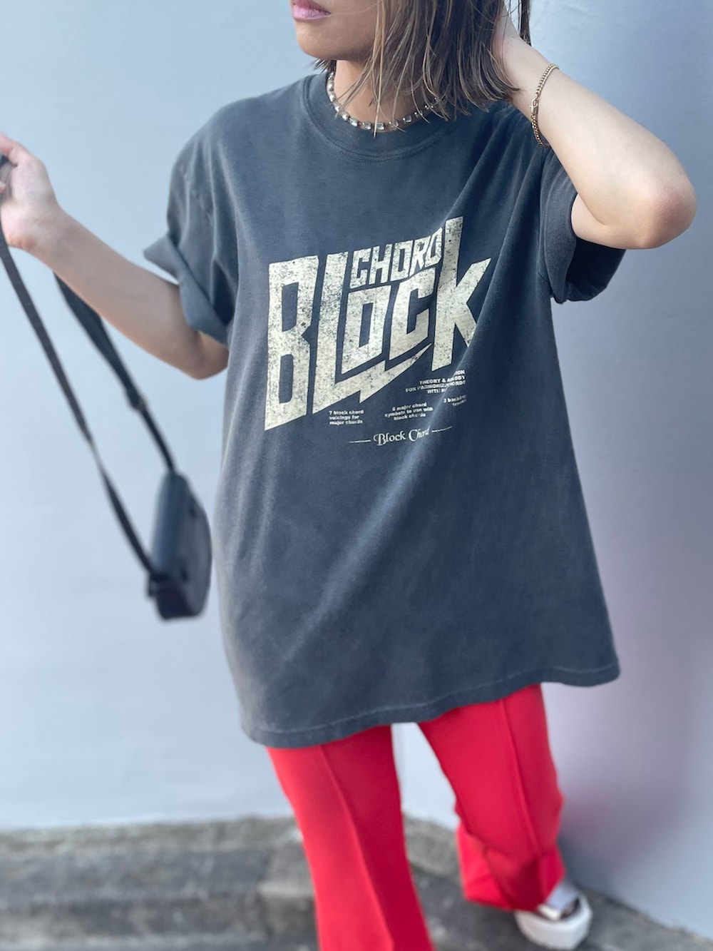 ブラック系のTシャツ/カットソー、オレンジ系のその他パンツを着用したレディースの夏コーディネートの3枚目の写真