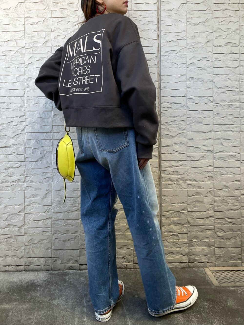 ブラック系のスウェット、オレンジ系のスニーカーを着用したレディースの冬コーディネートの4枚目の写真