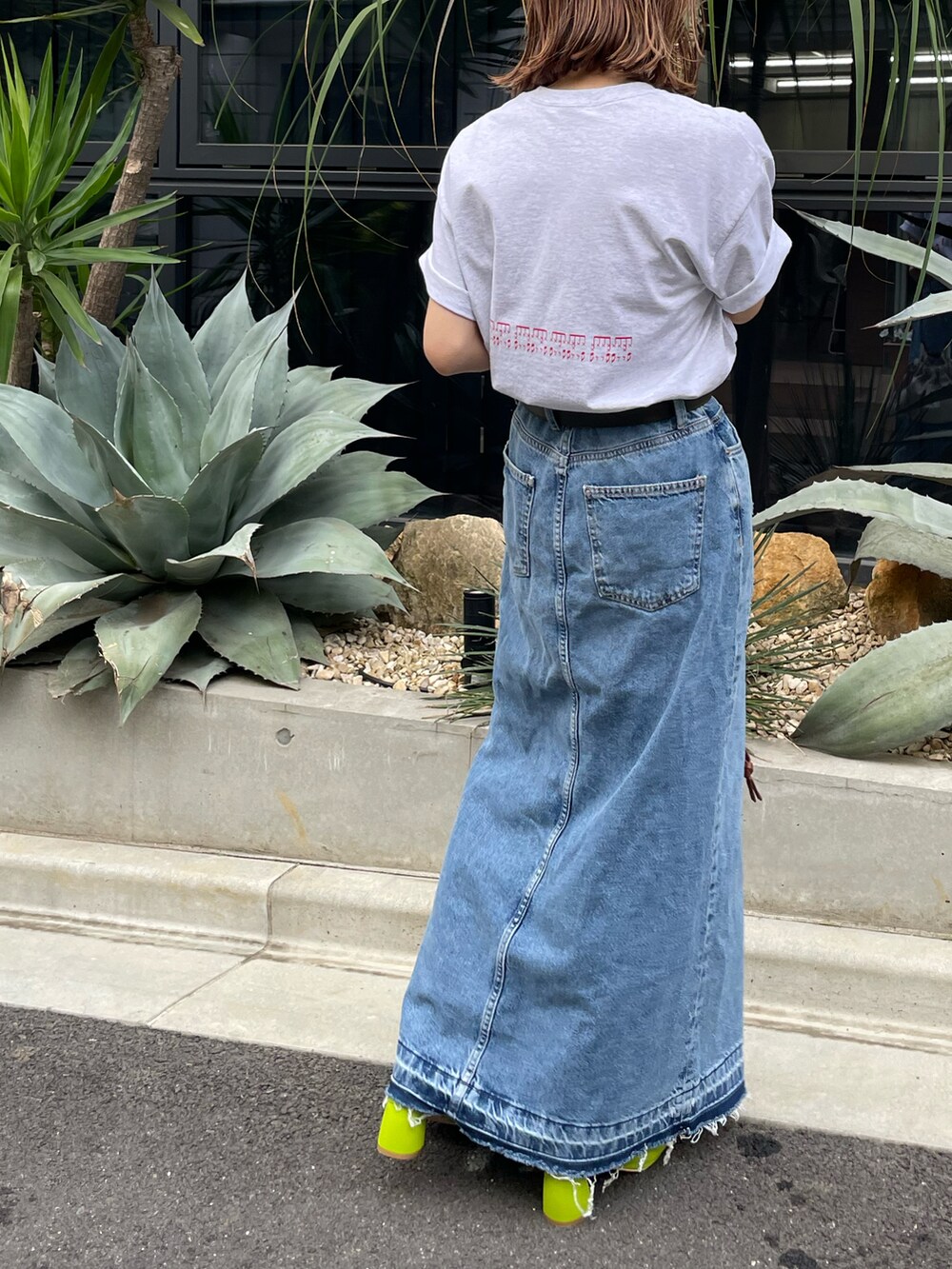 ベージュ系のTシャツ/カットソー、ブルー系のデニムスカートを着用したレディースの春コーディネートの2枚目の写真