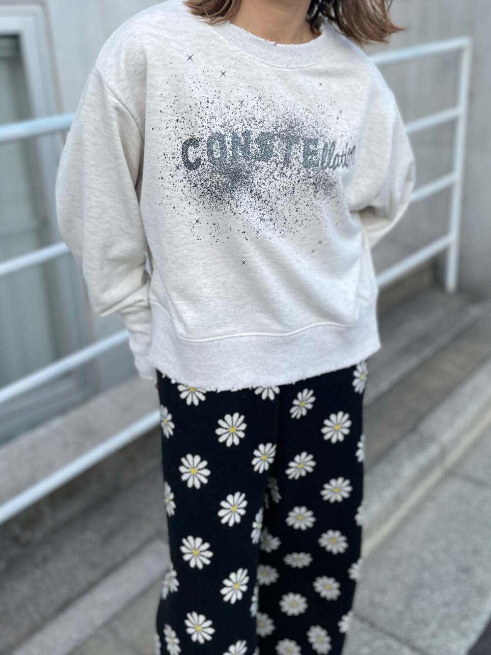 「春コーデ、春服みてみて、カジュアルコーデ、カジュアル、総柄、花柄、似合うラボに行こう、休日スタイル、ロゴスウェット、スウェット、ニット、ニットパンツ、イージーパンツ、mivialoca、mi via loca」｜「mi via locaのスウェットライク デイジー柄ジャガードパンツ（その他パンツ、ブラック系）」を使った、cocoさん（レディース・154cm）の春コーディネートの5枚目の写真