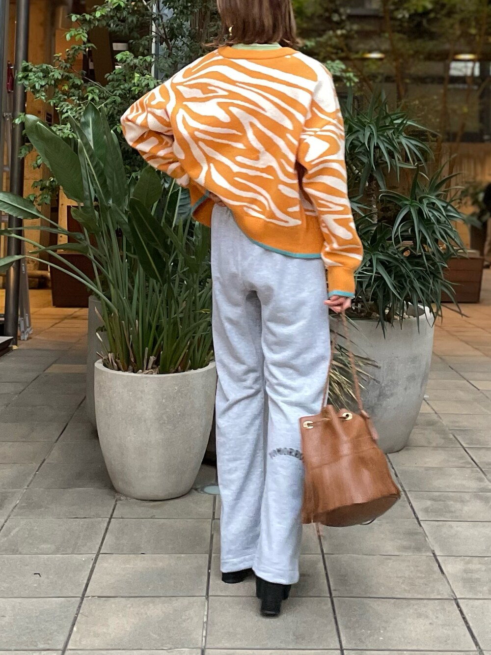 イエロー系のカーディガン/ボレロ、グレー系のスウェットパンツを着用したレディースの冬コーディネートの2枚目の写真