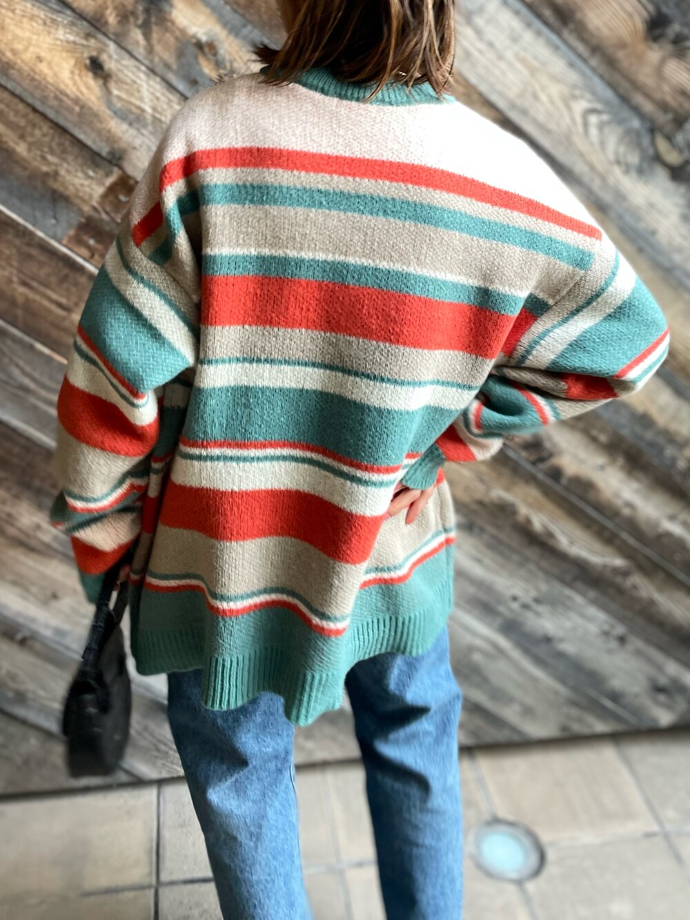 オレンジ系のニット/セーターを着用したレディースの冬コーディネートの4枚目の写真