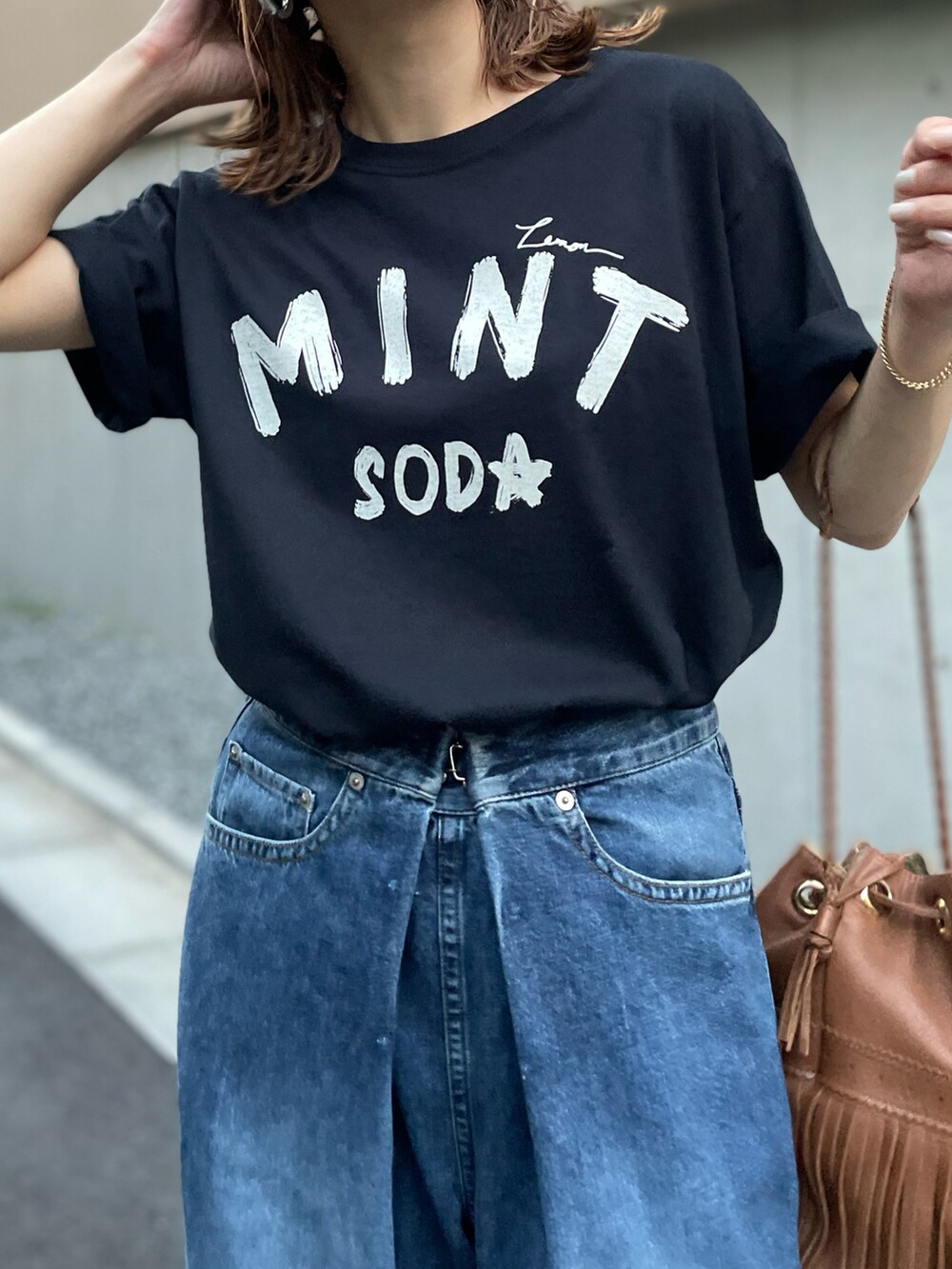 ブラック系のTシャツ/カットソーを着用したレディースの夏コーディネートの2枚目の写真