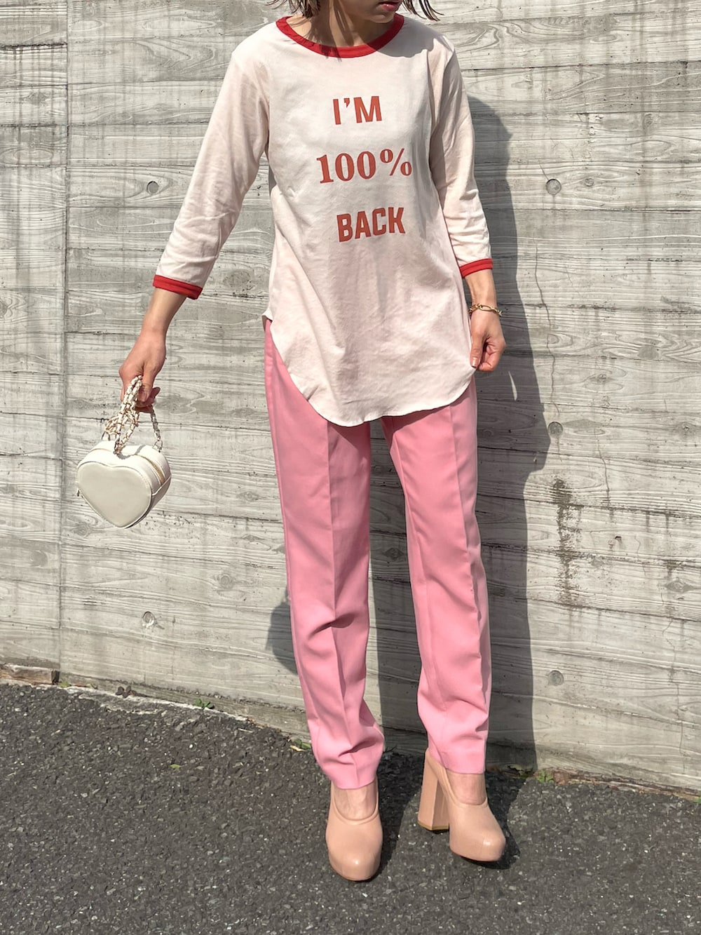 オレンジ系のTシャツ/カットソー、ピンク系のパンツを着用したレディースの春コーディネートの2枚目の写真