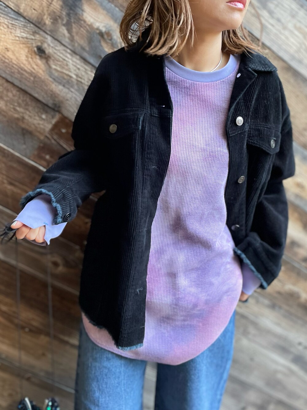 パープル系のTシャツ/カットソー、ブラック系のジャケット/アウター、ブルー系のデニムパンツを着用したレディースの冬コーディネートの4枚目の写真