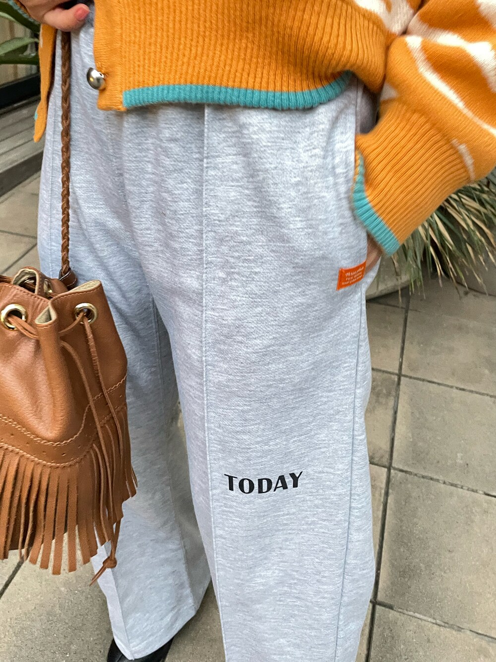 イエロー系のカーディガン/ボレロ、グレー系のスウェットパンツを着用したレディースの冬コーディネートの4枚目の写真