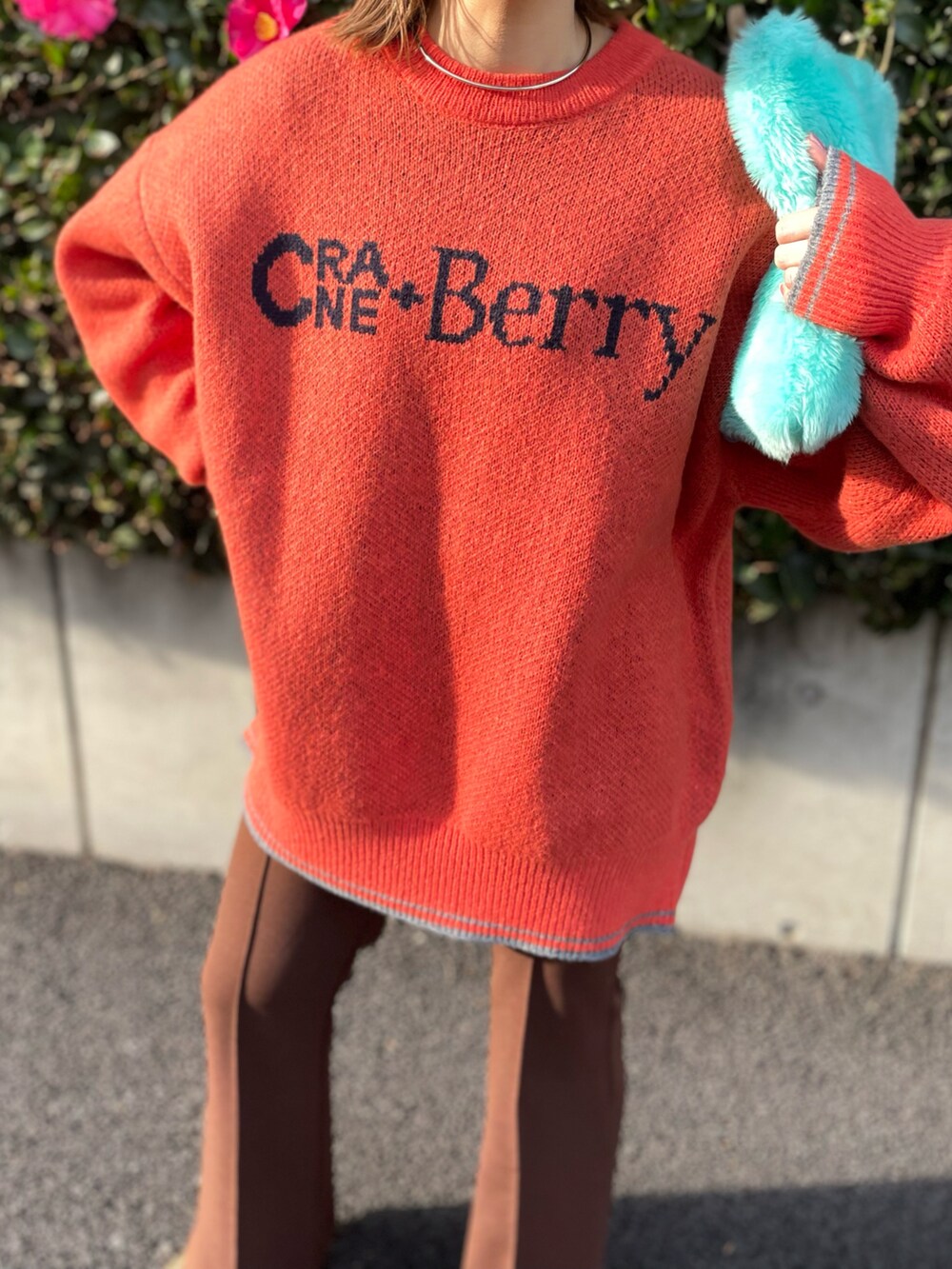 オレンジ系のニット/セーター、ブラウン系のその他パンツを着用したレディースの冬コーディネートの2枚目の写真