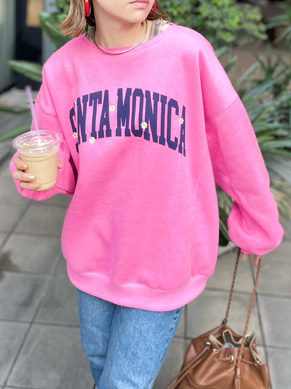 ピンク系のスウェット、ゴールド系のスニーカーを着用したレディースの冬コーディネートの3枚目の写真