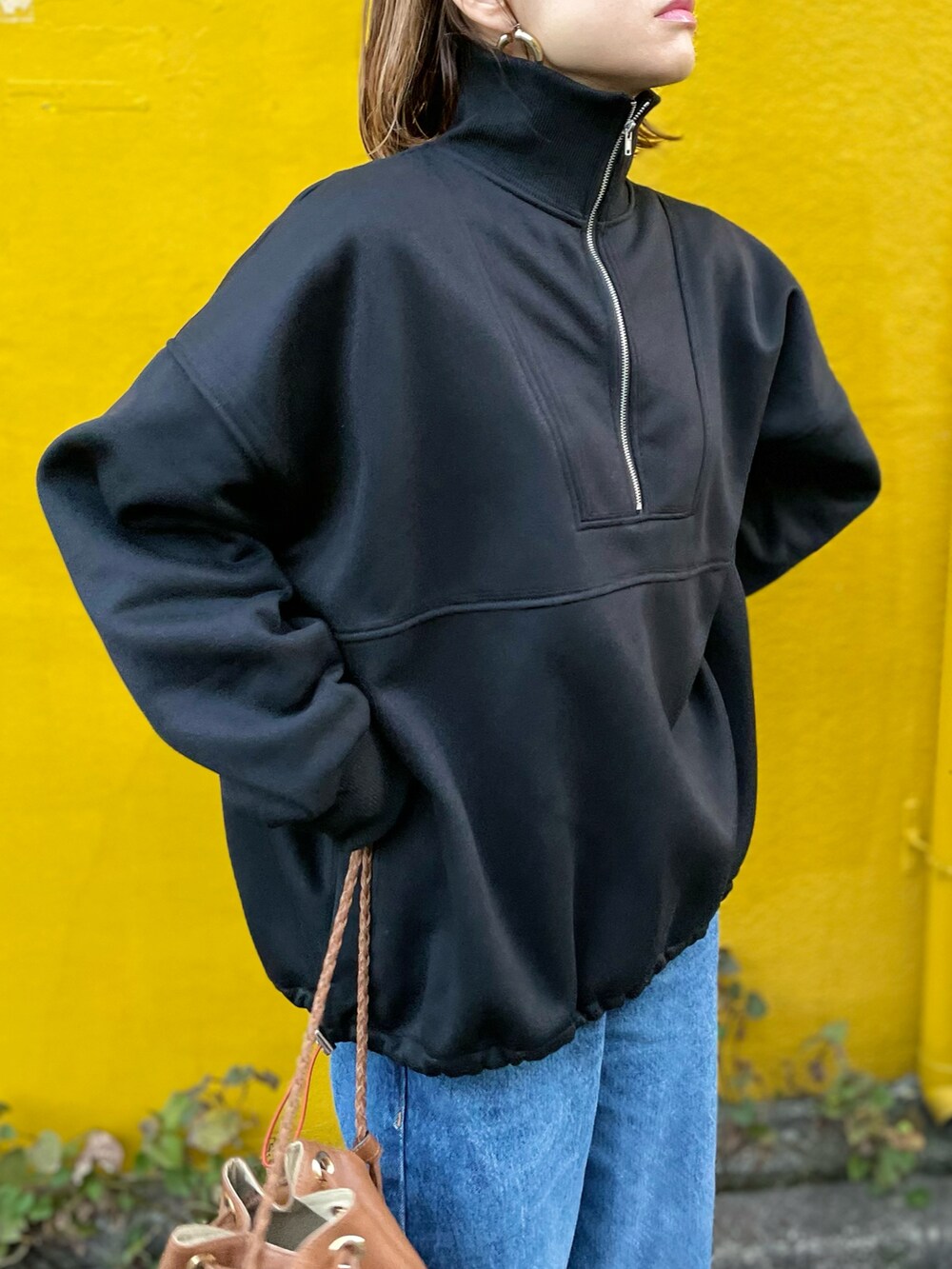 ブラック系のスウェット、ブルー系のデニムパンツを着用したレディースの秋コーディネートの3枚目の写真