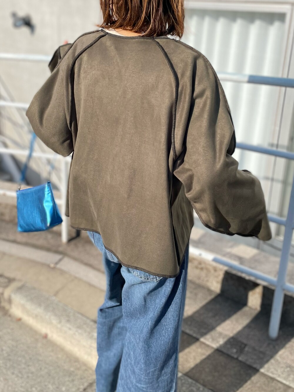 グリーン系のノーカラージャケット、ベージュ系のTシャツ/カットソーを着用したレディースの冬コーディネートの4枚目の写真