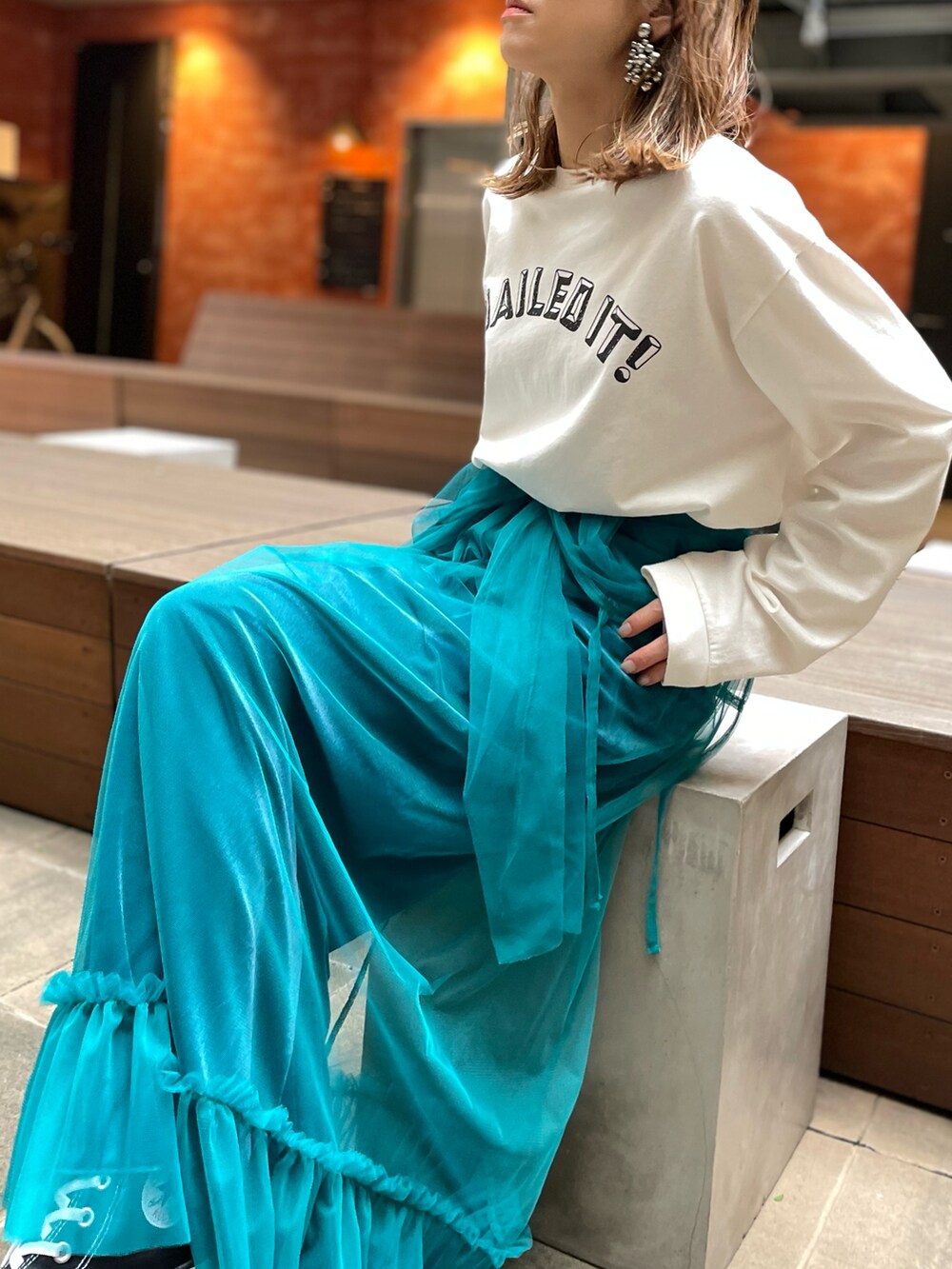 ホワイト系のTシャツ/カットソー、ブルー系のワンピース、ブラック系のスニーカーを着用したレディースの秋コーディネートの2枚目の写真