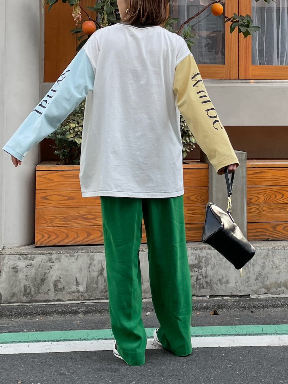 ホワイト系のTシャツ/カットソー、ブラック系のスニーカーを着用したレディースの春コーディネートの2枚目の写真