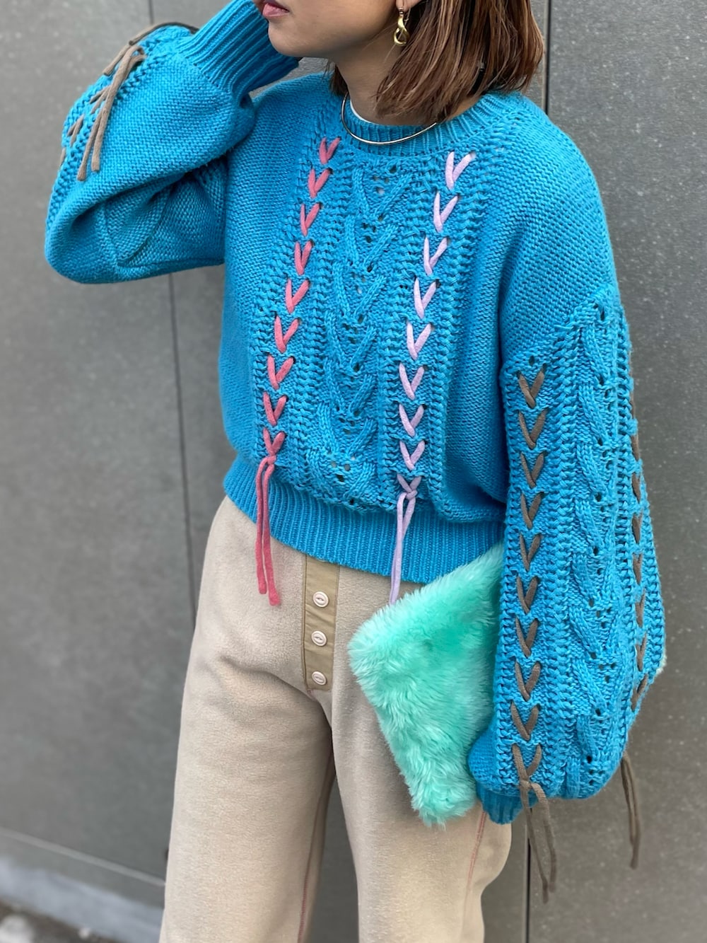 ブルー系のニット/セーター、ベージュ系のその他パンツ、ブラック系のブーツを着用したレディースの冬コーディネートの2枚目の写真