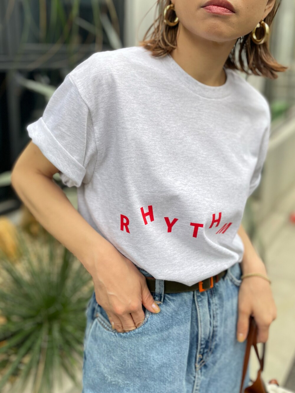 ベージュ系のTシャツ/カットソー、ブルー系のデニムスカートを着用したレディースの春コーディネートの4枚目の写真