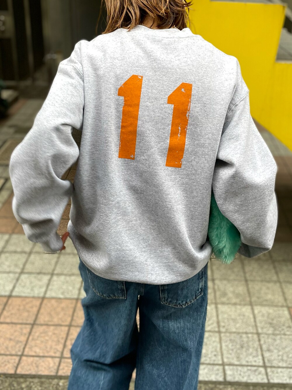 ブルー系のブルゾン、グレー系のスウェット、ブルー系のデニムパンツを着用したレディースの冬コーディネートの5枚目の写真