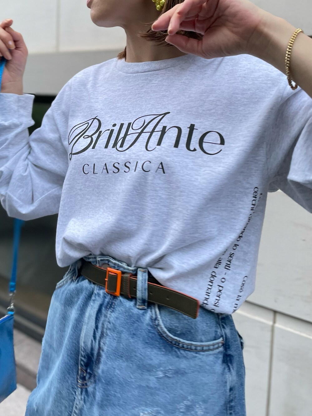 ベージュ系のTシャツ/カットソー、ブルー系のデニムスカートを着用したレディースの春コーディネートの3枚目の写真