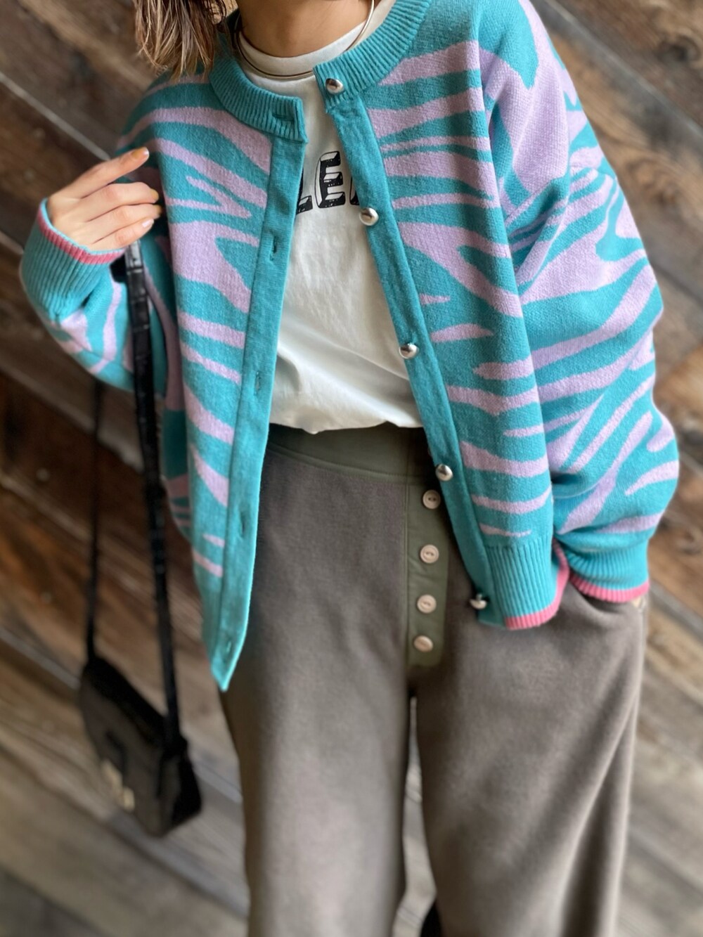 グレー系のその他パンツ、ブルー系のカーディガン/ボレロ、ホワイト系のTシャツ/カットソーを着用したレディースの冬コーディネートの4枚目の写真