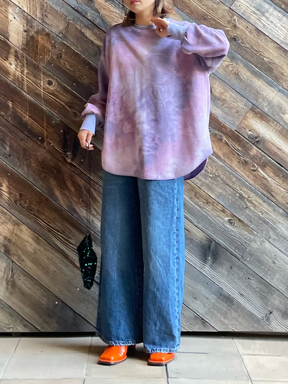 パープル系のTシャツ/カットソー、ブラック系のジャケット/アウター、ブルー系のデニムパンツを着用したレディースの冬コーディネートの3枚目の写真