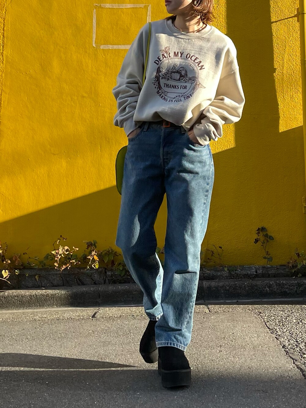 ブラック系のノーカラージャケット、ベージュ系のスウェット、ブラック系のブーツを着用したレディースの冬コーディネートの2枚目の写真