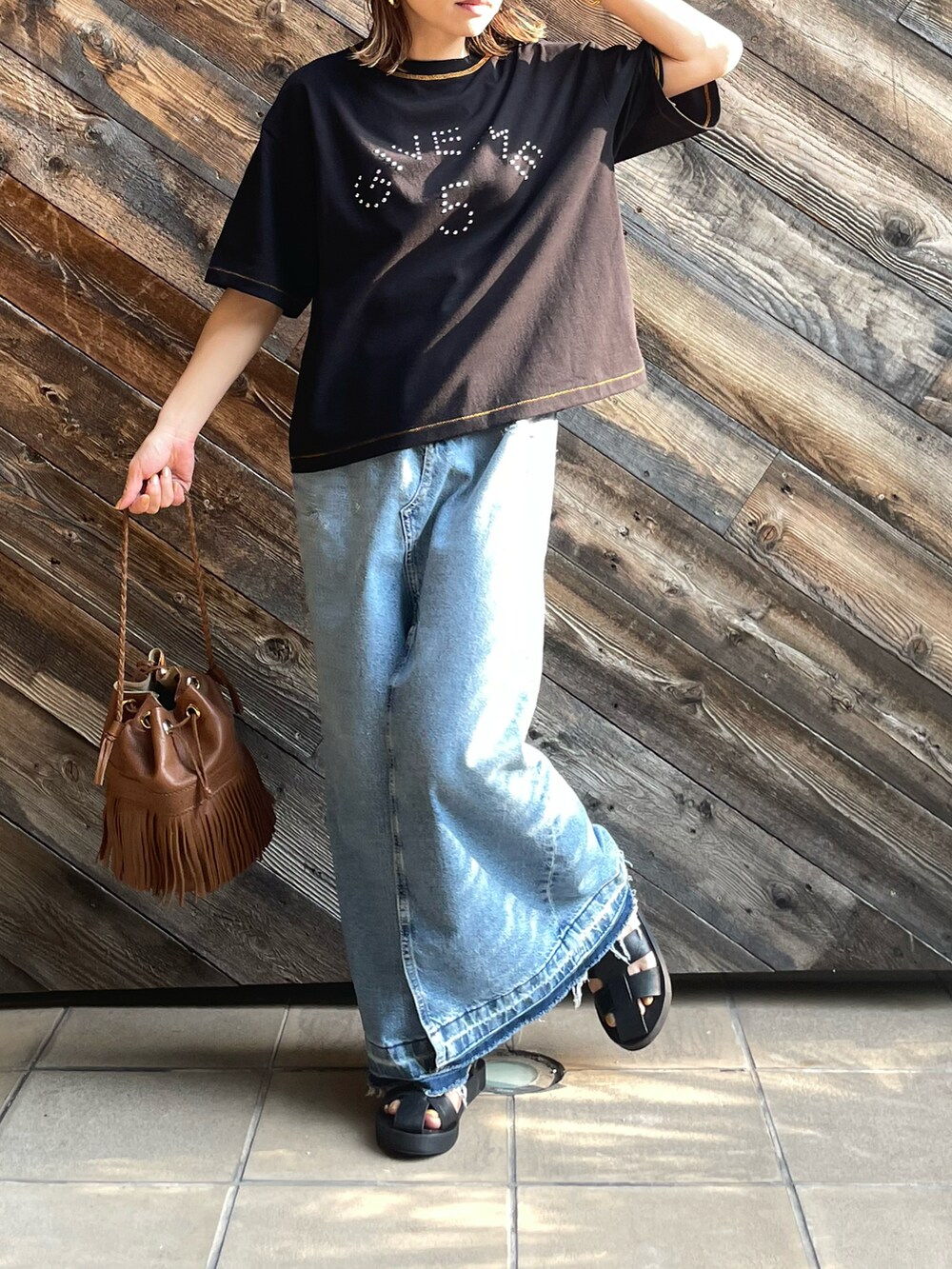 ブラック系のTシャツ/カットソー、ブルー系のデニムスカートを着用したレディースの夏コーディネートの4枚目の写真
