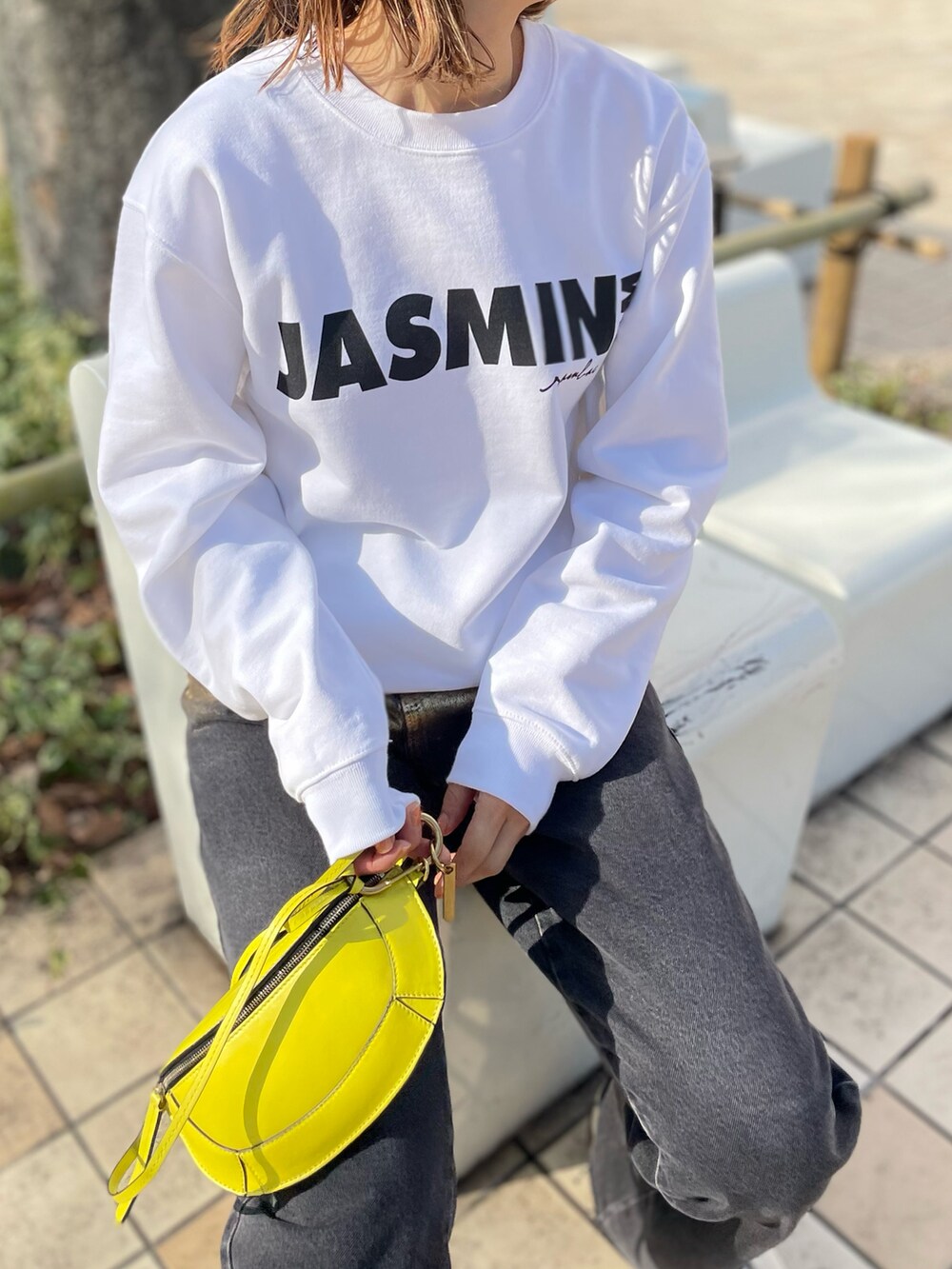 ホワイト系のスウェット、ブラック系のデニムパンツ、ホワイト系のスニーカーを着用したレディースの冬コーディネートの2枚目の写真