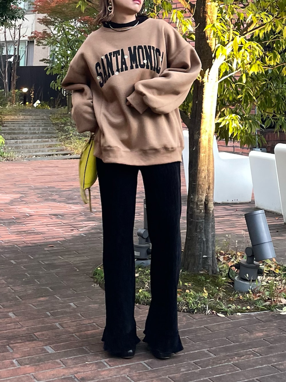 イエロー系のスウェット、ブラック系のその他パンツを着用したレディースの秋コーディネートの2枚目の写真