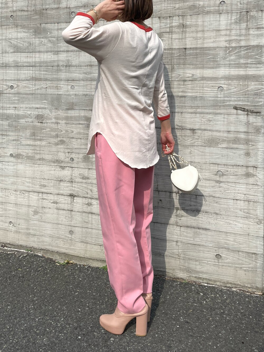 オレンジ系のTシャツ/カットソー、ピンク系のパンツを着用したレディースの春コーディネートの5枚目の写真