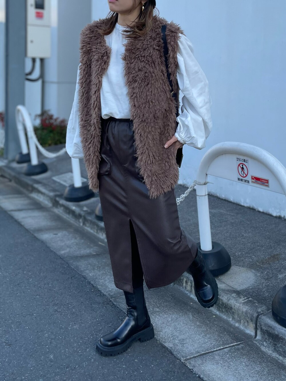 ブラウン系のベスト、ブラウン系のスカートを着用したレディースの冬コーディネートの3枚目の写真