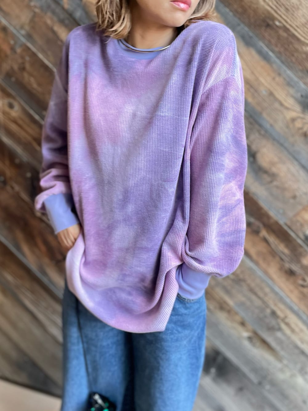 パープル系のTシャツ/カットソー、ブラック系のジャケット/アウター、ブルー系のデニムパンツを着用したレディースの冬コーディネートの2枚目の写真