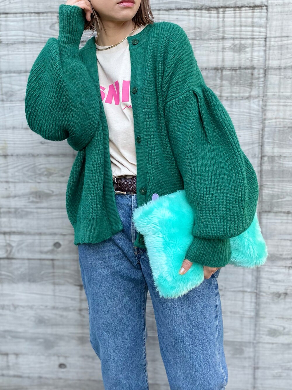 グリーン系のカーディガン/ボレロ、ベージュ系のTシャツ/カットソーを着用したレディースの秋コーディネートの3枚目の写真