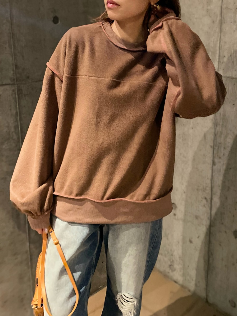 ベージュ系のスウェット、ブラウン系のベスト、ブラック系のブーツを着用したレディースの秋コーディネートの4枚目の写真