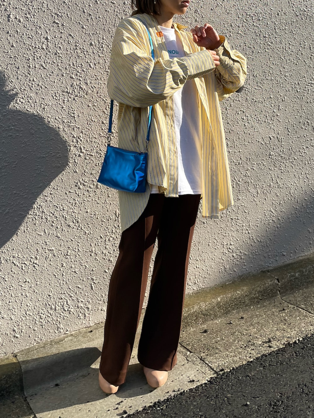 イエロー系のシャツ/ブラウス、ブラウン系のその他パンツ、ホワイト系のTシャツ/カットソーを着用したレディースの春コーディネートの4枚目の写真