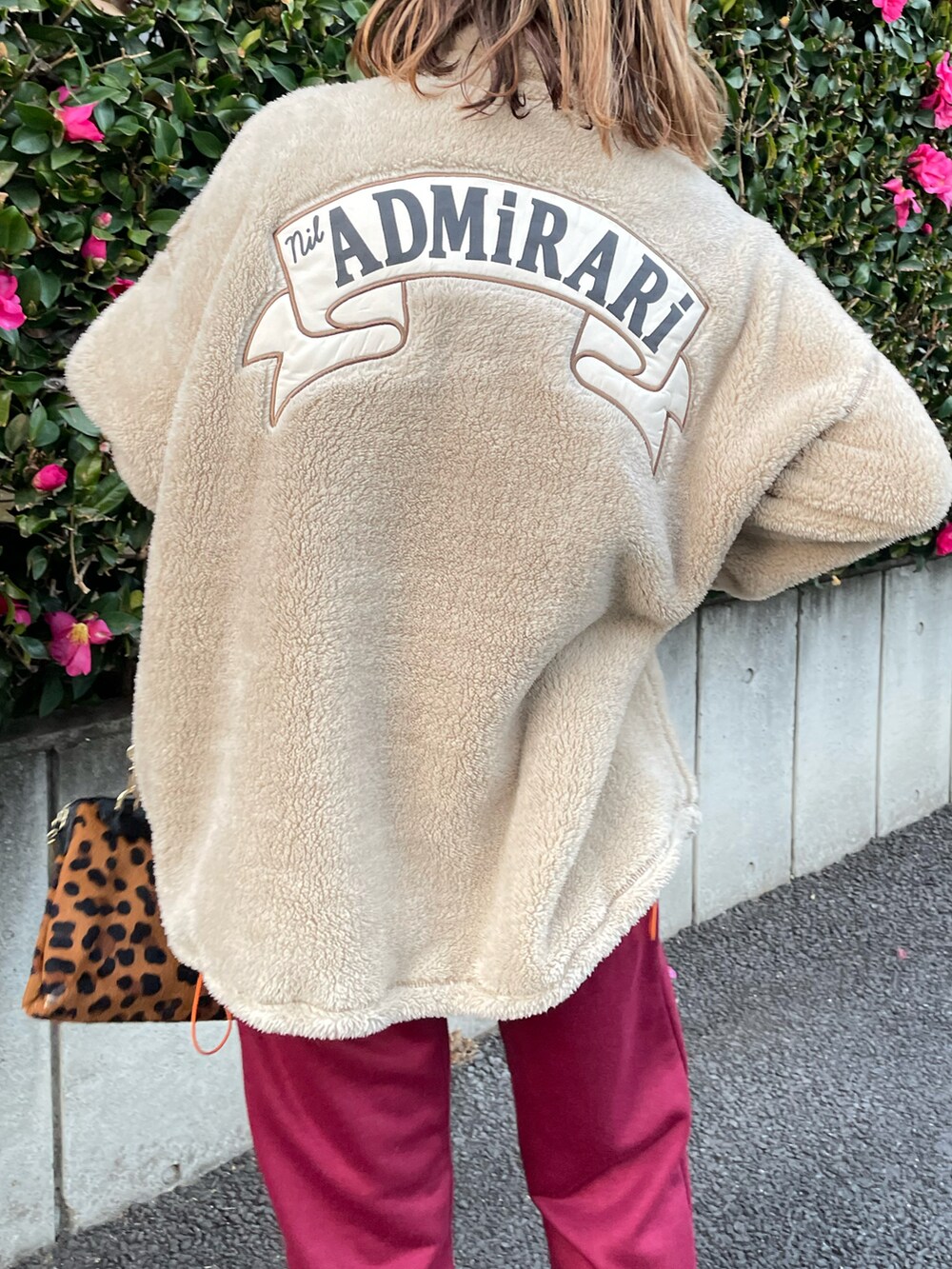 ベージュ系のスウェット、レッド系のスウェットパンツ、ブラック系のブーツを着用したレディースの冬コーディネートの4枚目の写真