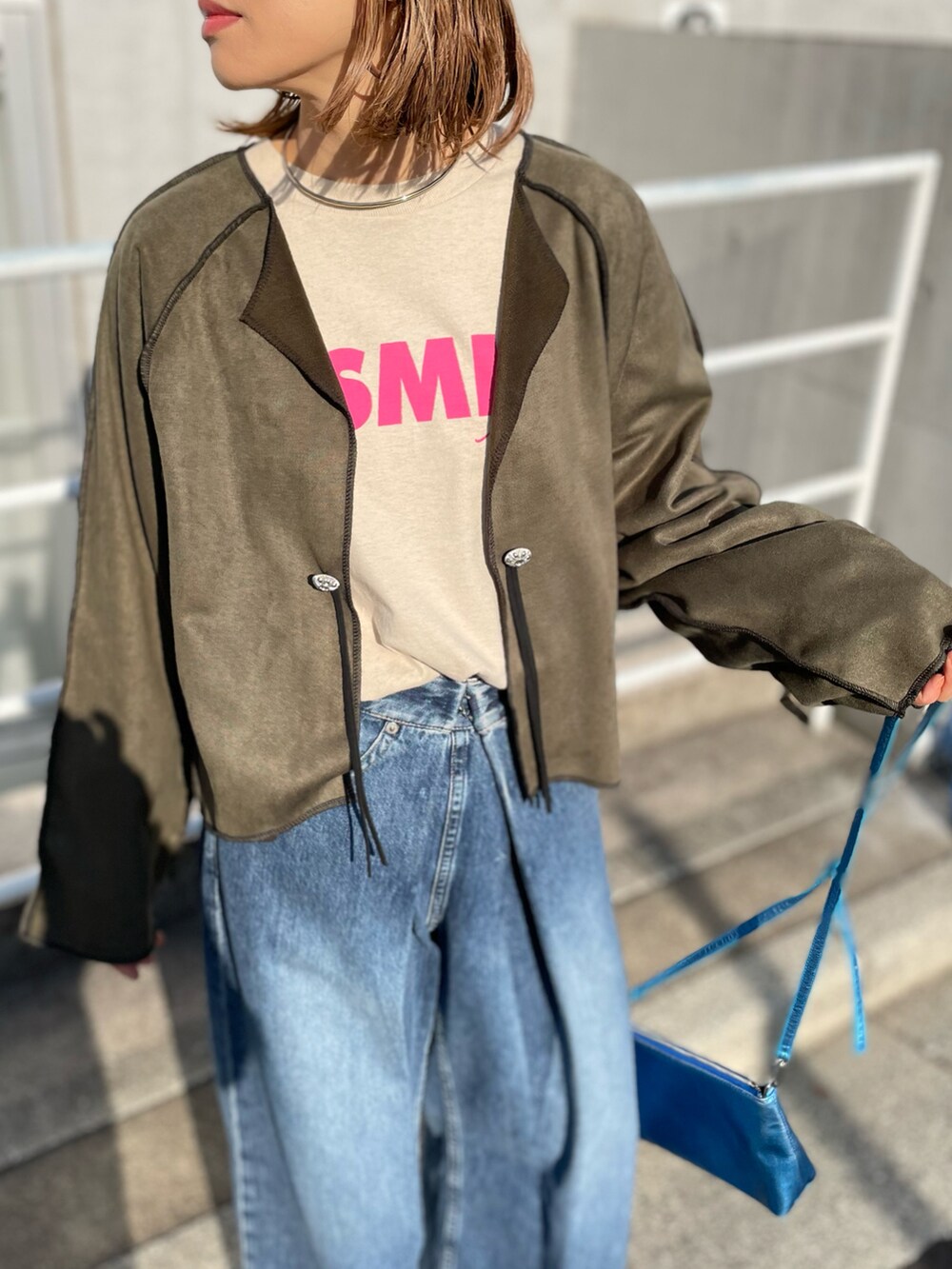 グリーン系のノーカラージャケット、ベージュ系のTシャツ/カットソーを着用したレディースの冬コーディネートの3枚目の写真