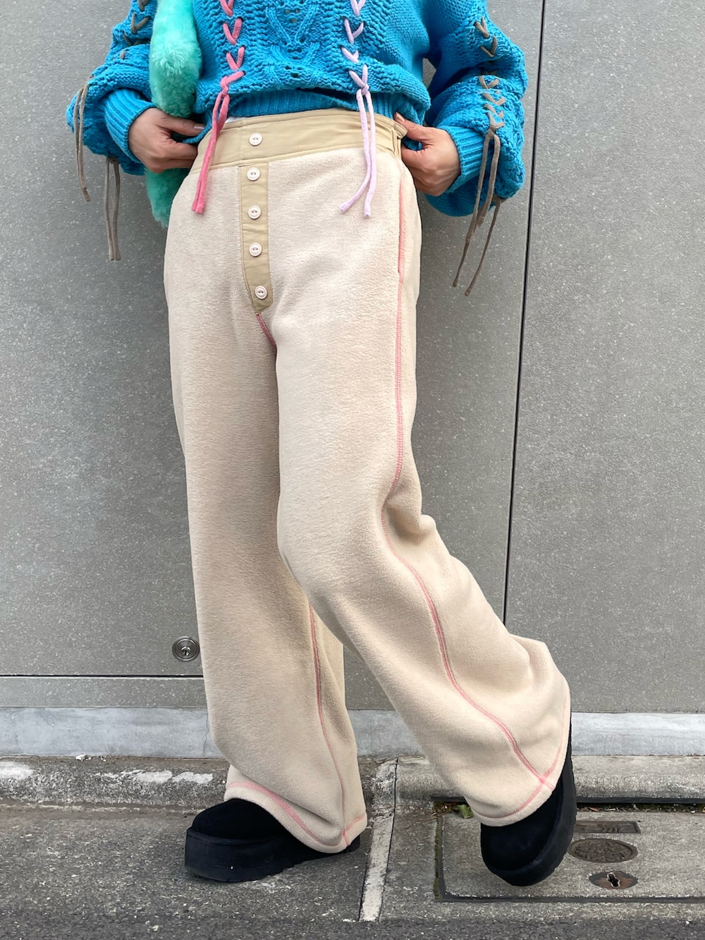 ブルー系のニット/セーター、ベージュ系のその他パンツ、ブラック系のブーツを着用したレディースの冬コーディネートの4枚目の写真