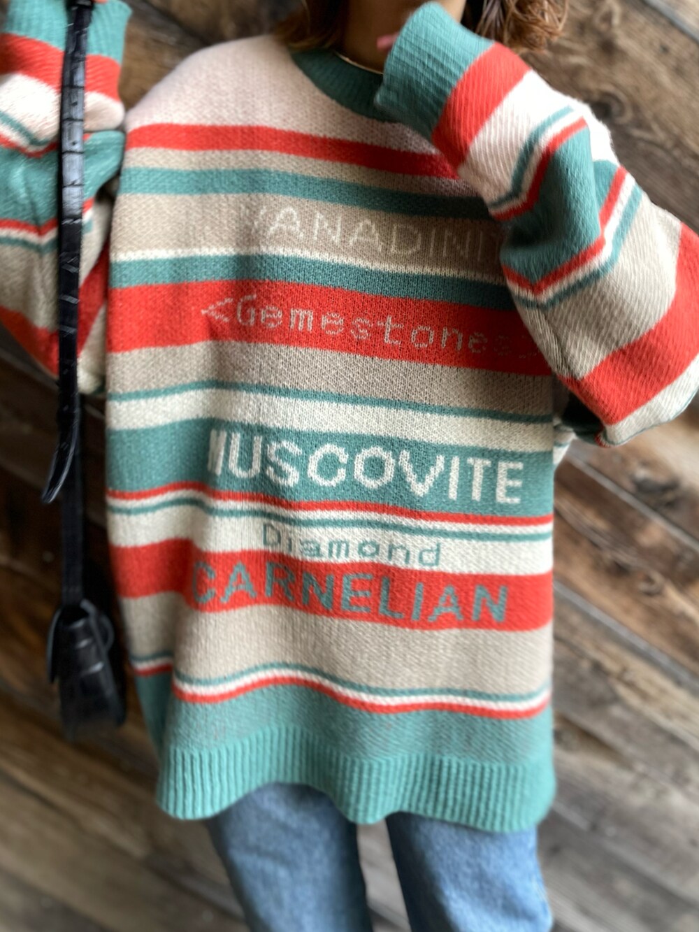 オレンジ系のニット/セーターを着用したレディースの冬コーディネートの2枚目の写真