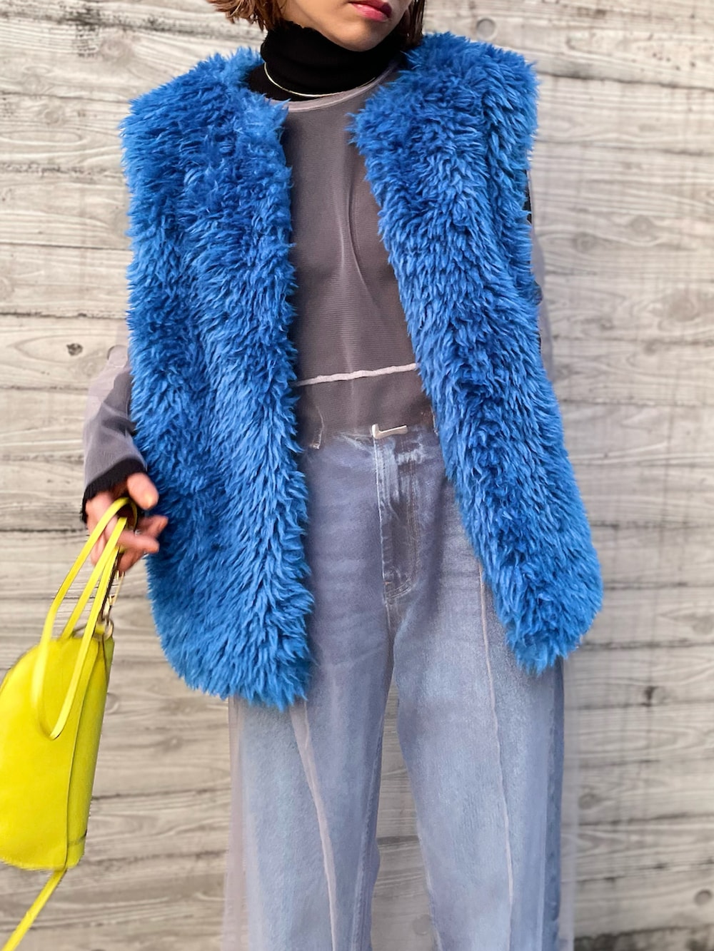 ブルー系のベスト、グレー系のワンピースを着用したレディースの秋コーディネートの2枚目の写真