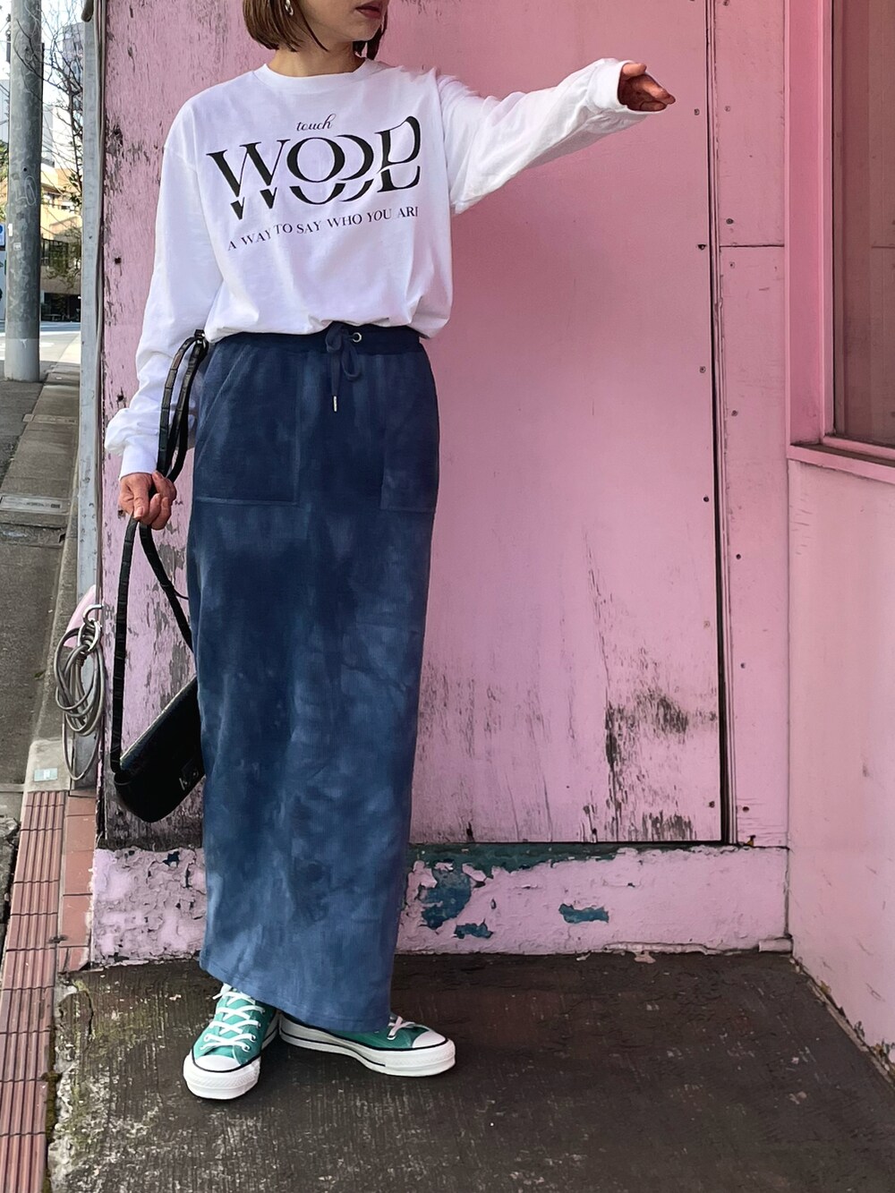 ブルー系のスカート、グリーン系のスニーカー、ホワイト系のTシャツ/カットソーを着用したレディースの春コーディネートの3枚目の写真