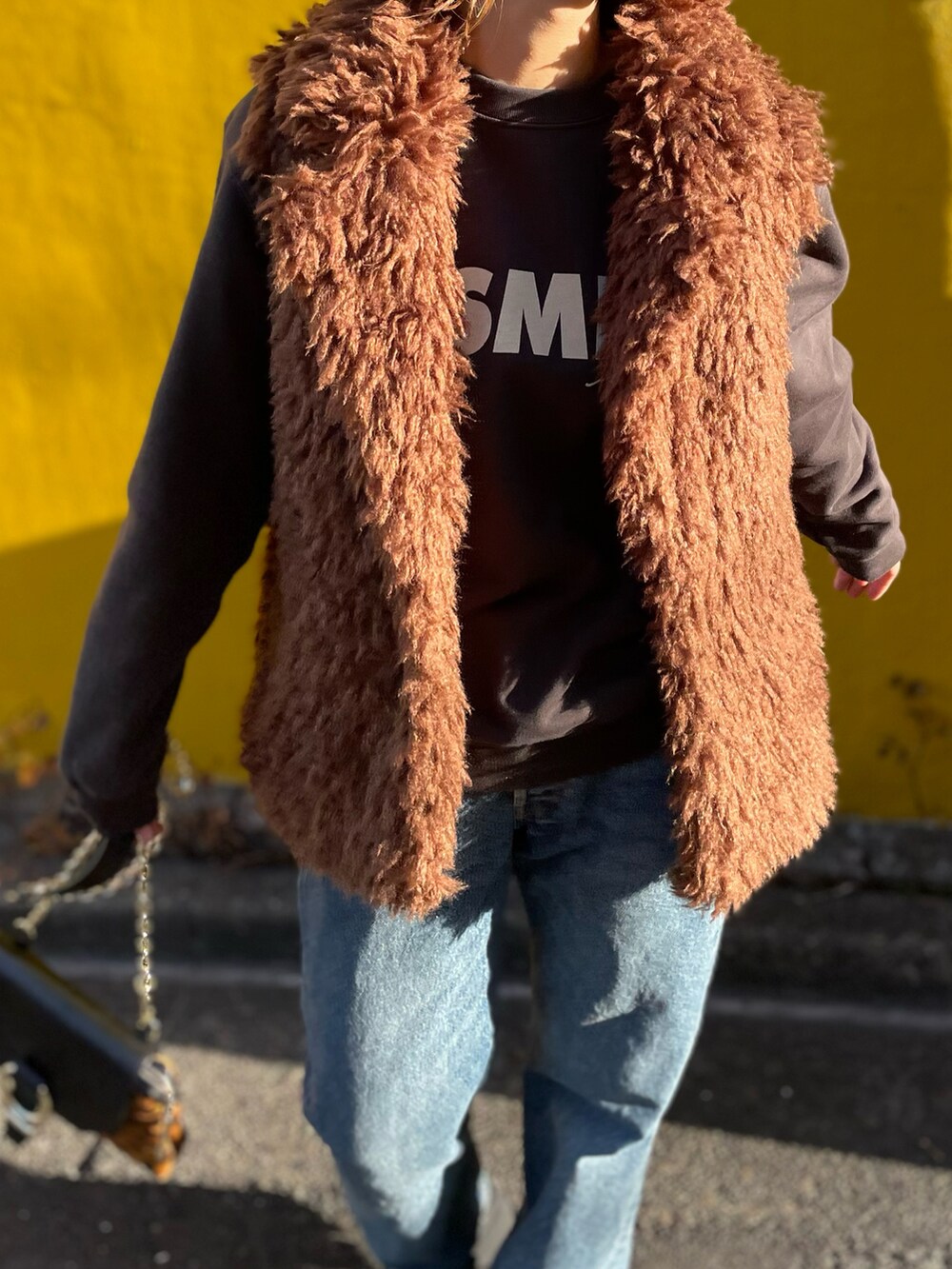 ブラウン系のベスト、ブラック系のスウェットを着用したレディースの冬コーディネートの4枚目の写真