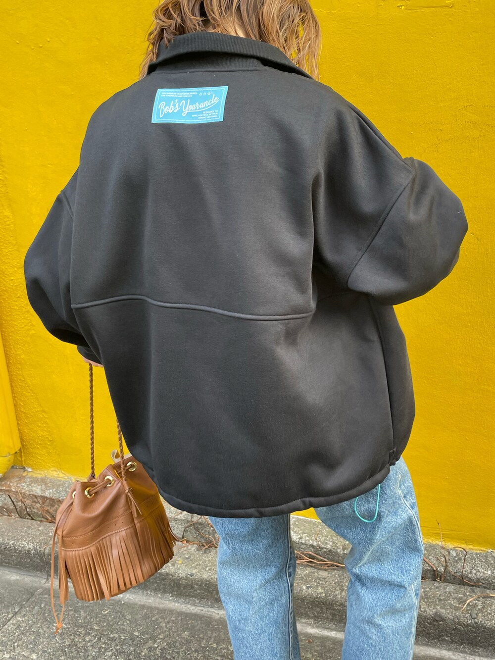 ブラック系のスウェット、ホワイト系のスニーカーを着用したレディースの冬コーディネートの3枚目の写真