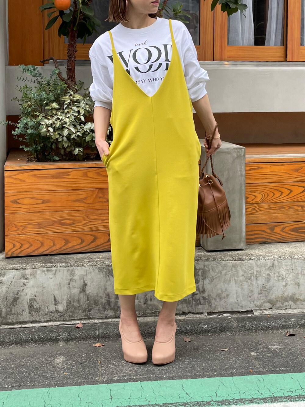 グリーン系のワンピース、ホワイト系のTシャツ/カットソーを着用したレディースの春コーディネートの2枚目の写真