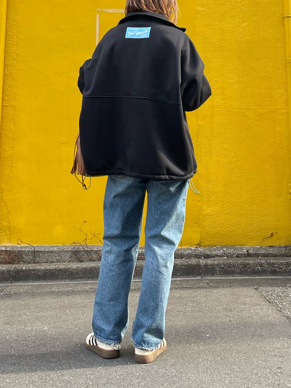 ブラック系のスウェット、ホワイト系のスニーカーを着用したレディースの冬コーディネートの2枚目の写真