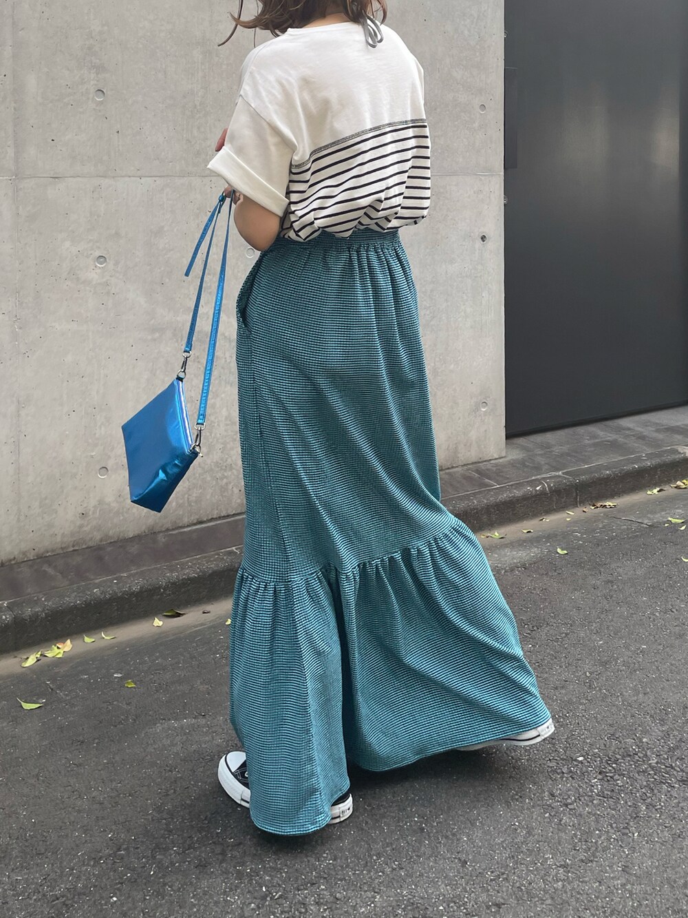 ホワイト系のTシャツ/カットソー、ブラック系のシューズ、ブルー系のスカートを着用したレディースの夏コーディネートの2枚目の写真