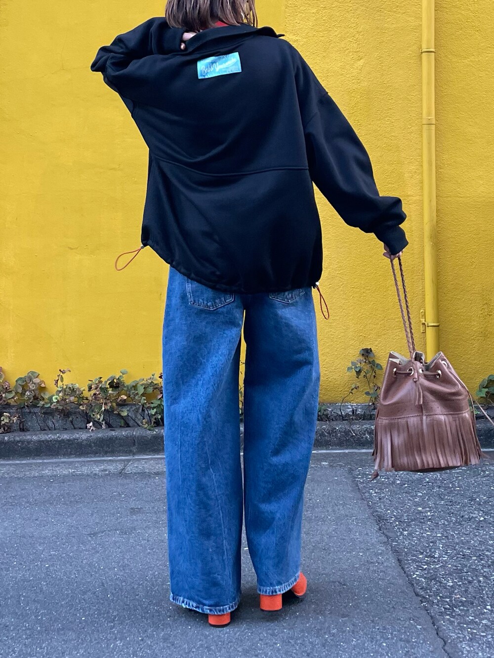 ブラック系のスウェット、ブルー系のデニムパンツを着用したレディースの秋コーディネートの2枚目の写真