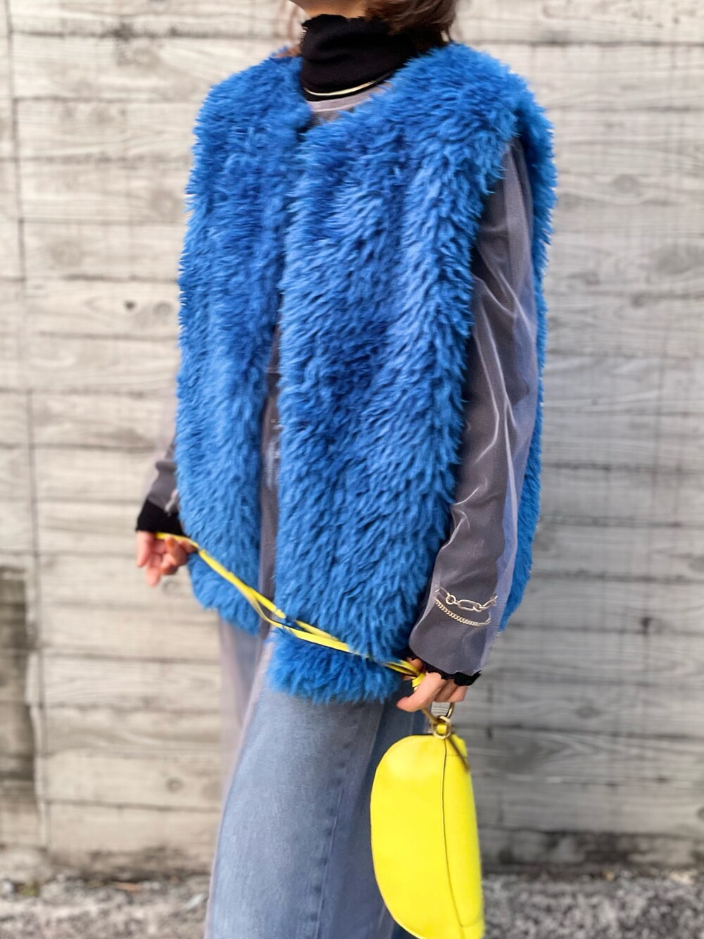 ブルー系のベスト、グレー系のワンピースを着用したレディースの秋コーディネートの3枚目の写真