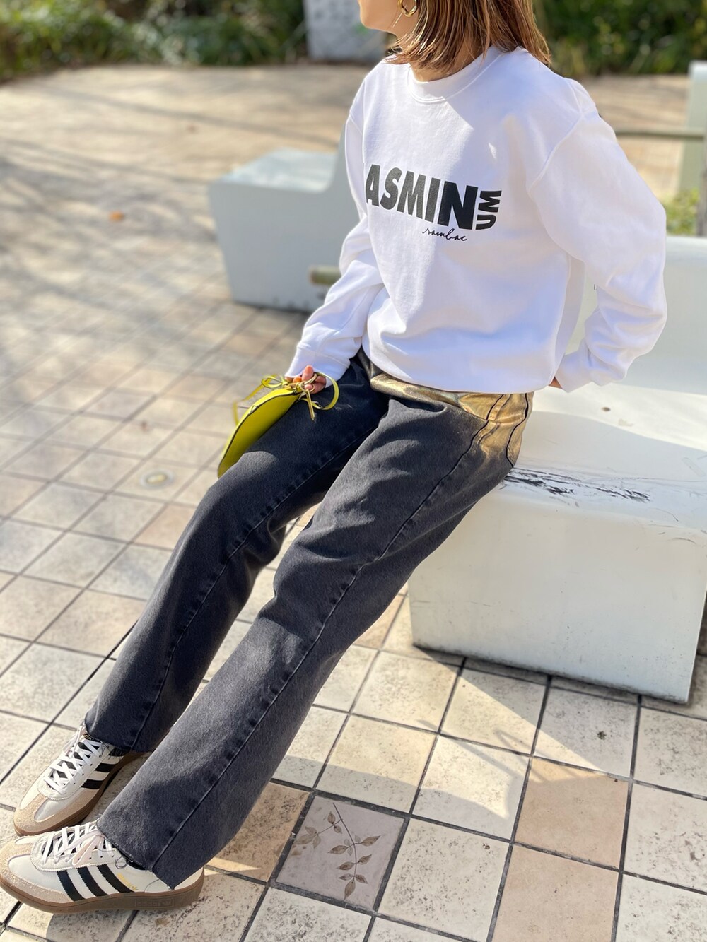 ホワイト系のスウェット、ブラック系のデニムパンツ、ホワイト系のスニーカーを着用したレディースの冬コーディネートの5枚目の写真