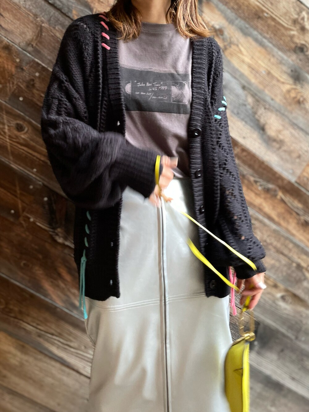 シルバー系のスカート、ブラック系のカーディガン/ボレロ、グレー系のTシャツ/カットソーを着用したレディースの秋コーディネートの4枚目の写真