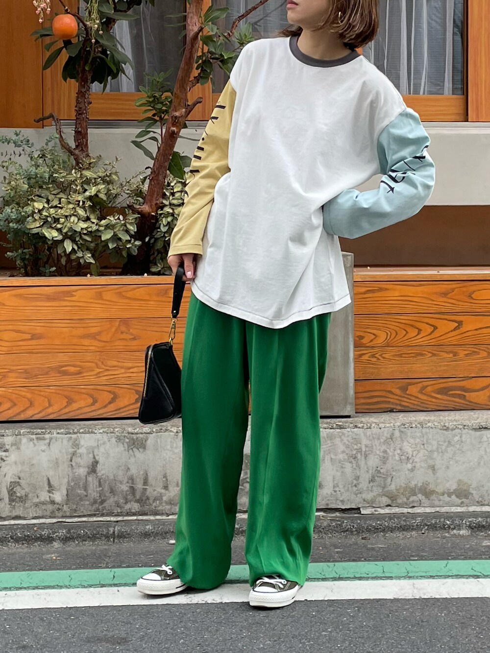 ホワイト系のTシャツ/カットソー、ブラック系のスニーカーを着用したレディースの春コーディネートの3枚目の写真