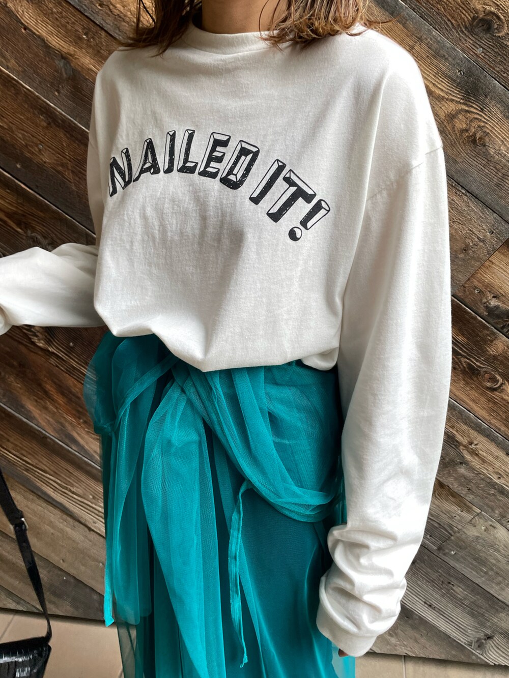 ホワイト系のTシャツ/カットソー、ブルー系のワンピース、ブラック系のスニーカーを着用したレディースの秋コーディネートの4枚目の写真