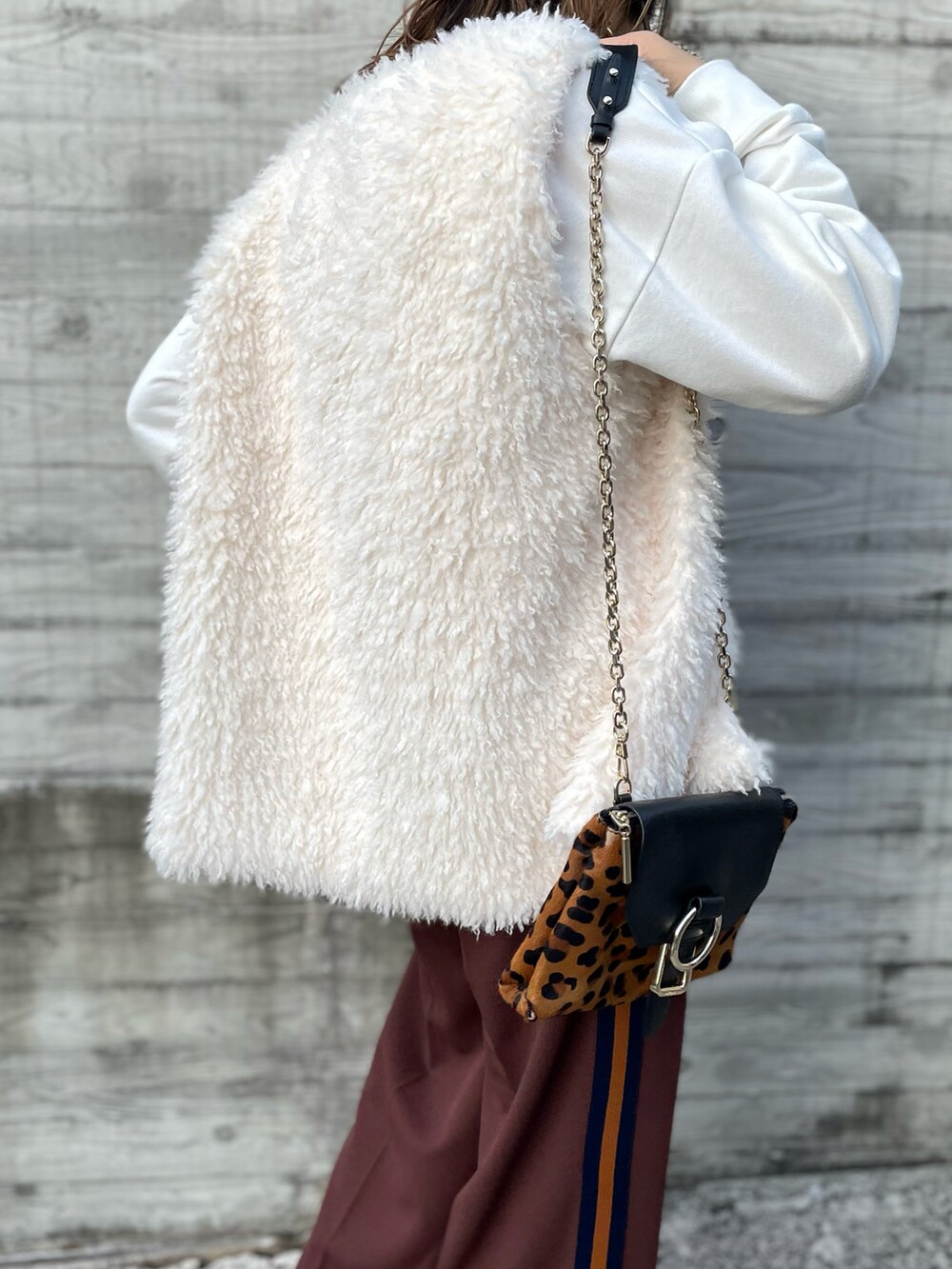 ホワイト系のベスト、ホワイト系のスウェット、ブラウン系のその他パンツを着用したレディースの秋コーディネートの3枚目の写真